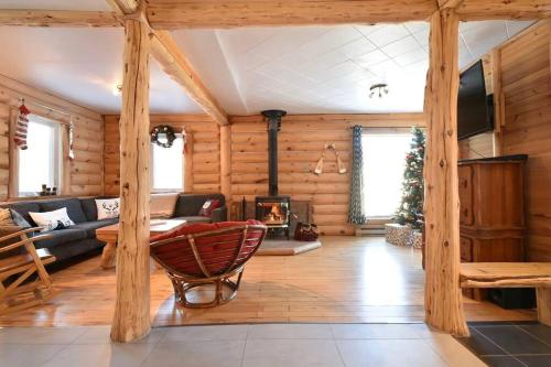 a living room with a fireplace in a log cabin at Chalet du lac avec SPA privé, wifi, BBQ et SUP in Saint Adolphe D'Howard
