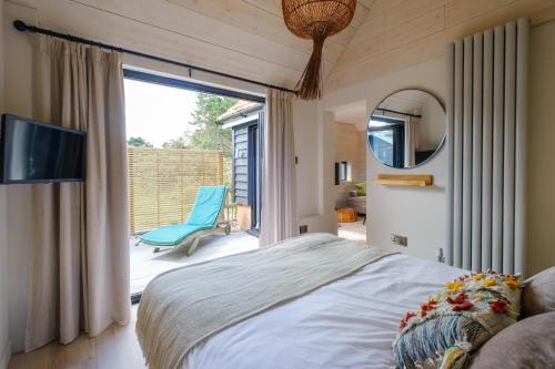 1 dormitorio con cama y ventana grande en Mission Lodge, en Thorpeness