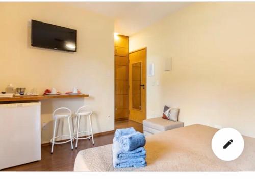 a room with a kitchen and a living room at Condomínio Flat Piemonte in Serra Negra