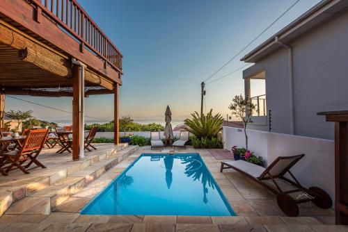 a swimming pool on the patio of a house at Aquamarine Guest House in Mossel Bay