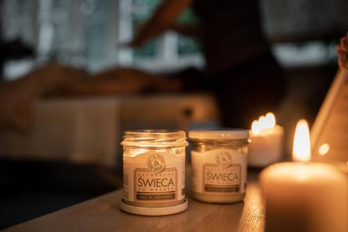 two jars of soy sauce sitting next to candles at Hotel&SPA Dwór Droblin in Leśna Podlaska