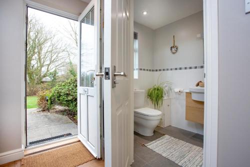 a bathroom with a toilet and a sink at Puffin Leigh Cottages in Seaton