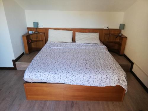 ロゾリーナ・マーレにあるVilla Albarellaのベッドルーム1室(木製ヘッドボード付きのベッド1台付)