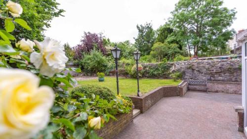 a garden with two street lights and roses at Waterloo Town House & Suites in Dublin