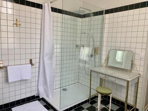 a bathroom with a glass shower with a sink and a stool at Château Le Repos in Rouffignac-de-Sigoulès