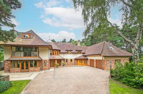 a large house with a driveway in front of it at Scotsdale - exclusive family home in Ringwood