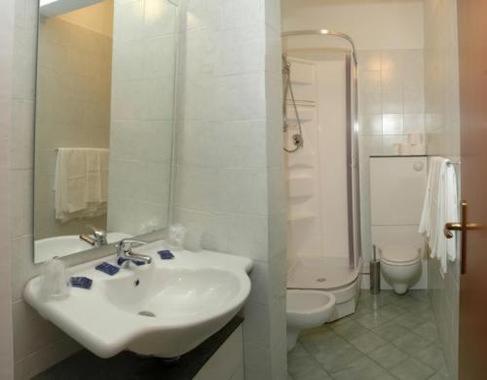 a white bathroom with a sink and a toilet at Hotel Toscana in Prato
