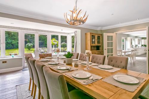 a dining room with a long table and chairs at Scotsdale - exclusive family home in Ringwood