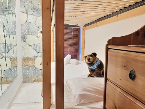 un chien assis sur un lit dans une chambre dans l'établissement Spacieux 2 pièces cabine avec balcon, WiFi et cheminée à Tignes - FR-1-411-678, à Tignes