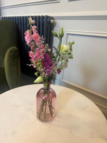 a vase filled with flowers sitting on a table at Waterloo Town House & Suites in Dublin