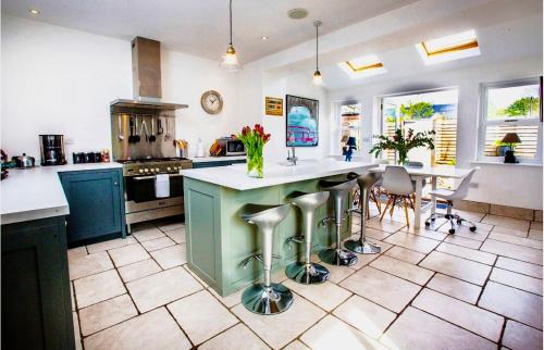 a kitchen with blue cabinets and a island with stools at SUNNYBECK COTTAGE Award winning DOG friendly in Settle