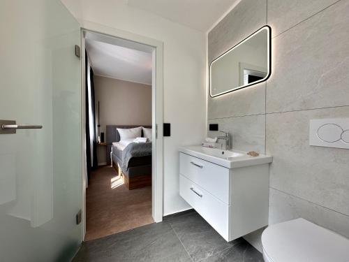 a bathroom with a sink and a mirror and a bed at Hotel Emilia in Würzburg