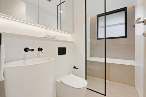 a bathroom with a toilet and a sink and a mirror at THE SHORE COOGEE BEACH (3) in Sydney