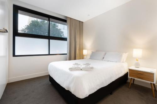 1 dormitorio con 1 cama blanca grande y ventana en THE SHORE COOGEE BEACH (3) en Sídney