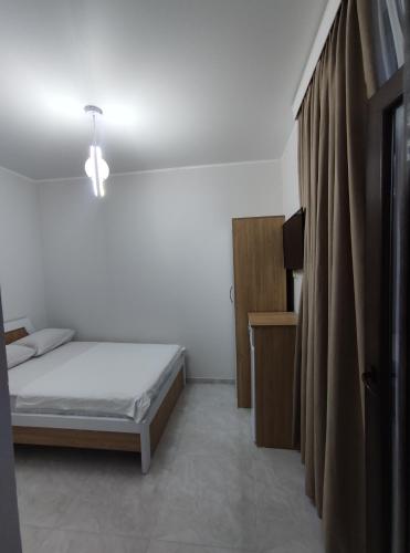 a small bedroom with a bed and a curtain at The best guest house-GAIOZ in Gonio