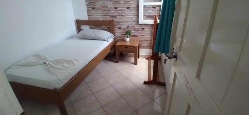 a small bedroom with a bed and a table at Pensão Domingas in São Filipe