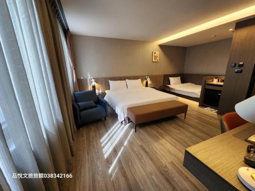 a hotel room with a bed and a chair at Hualien Pink Corner Hotel in Hualien City
