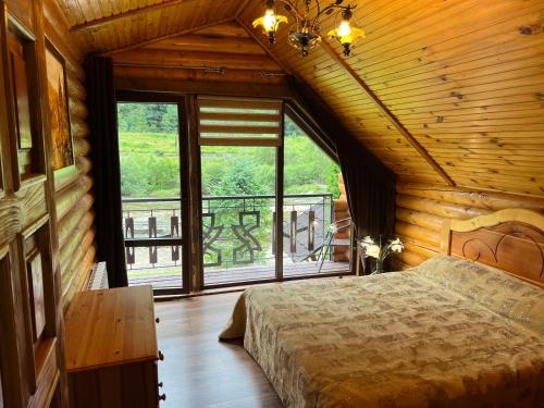 a bedroom with a bed and a large window at Zatin in Yaremche