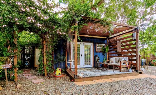 a tiny house in a garden with a patio at Cozy AF Tiny-House Oasis in Tampa