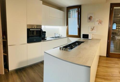 a kitchen with white cabinets and a counter top at La Mocina casa vacanze in Castellaro