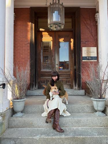 a woman sitting on the steps with a dog at The Francis Hotel in Portland