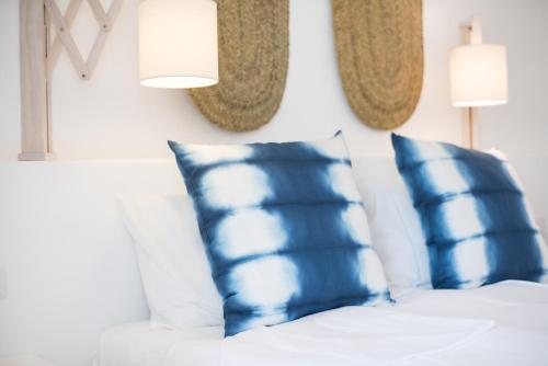 a bedroom with blue and white pillows on a bed at Octant Vila Monte in Moncarapacho