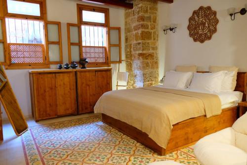 a bedroom with a bed in a room with windows at Suzanne Suite in ‘Akko