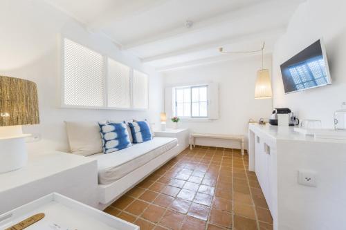 a living room with a white couch and a kitchen at Octant Vila Monte in Moncarapacho