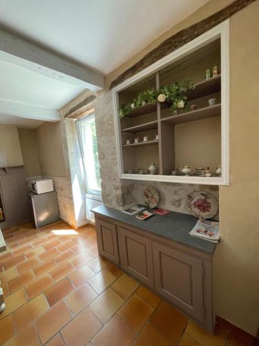 a kitchen with a counter in a room with a window at La Bohème in Condom