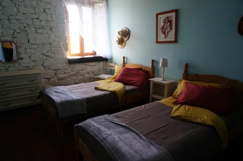 a bedroom with two beds and a window at Gite Les Volets Bleus du Segur in Le Ségur-Suech