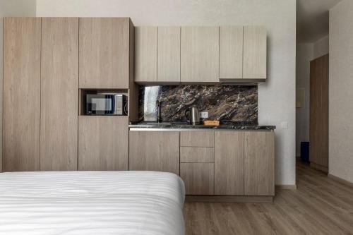 a bedroom with a bed and a kitchen at barasport city apartments in Kyiv