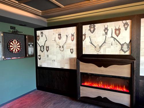 a room with a fireplace with deer heads and a clock at Lohmann's Kapeller Hof in Langenfeld
