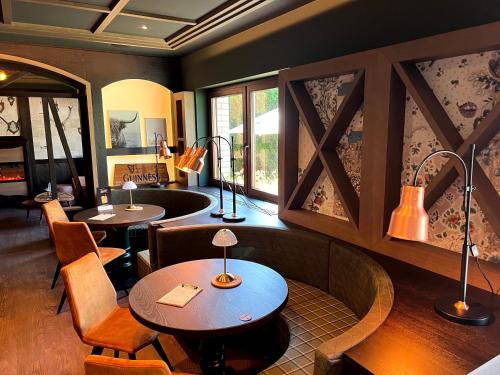 a restaurant with two tables and chairs and windows at Lohmann's Kapeller Hof in Langenfeld
