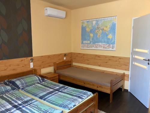 a room with two beds and a map on the wall at Adél Apartman in Sárvár