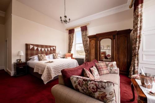a bedroom with a bed and a couch at Nithbank Country Estate 5 Star GOLD in Thornhill