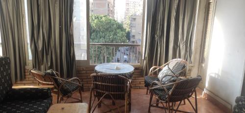 een kamer met een tafel en stoelen en een raam bij Morra in Caïro