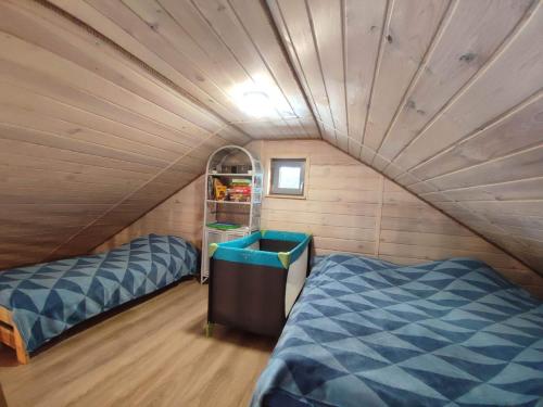 a room with two beds in a tiny house at Mazury Dom Oluś nad jeziorem Sasek Wielki z gorącą balia z funkcją jakuzzi in Szczytno
