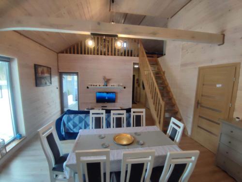 a kitchen and dining room with a table and chairs at Mazury Dom Oluś nad jeziorem Sasek Wielki z gorącą balia z funkcją jakuzzi in Szczytno