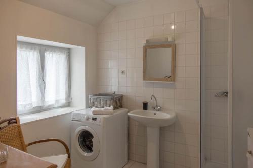 a bathroom with a washing machine and a sink at Coeur de Blois Maison T3 in Blois