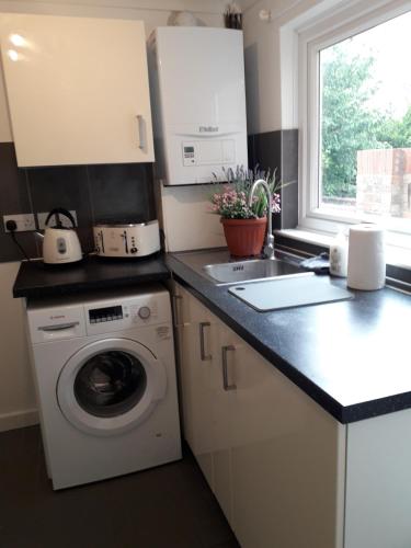 a kitchen with a washing machine and a window at Luxury 4 Bedroom City Centre Retreat FREE PARKING & FREE WIFI in Bedford