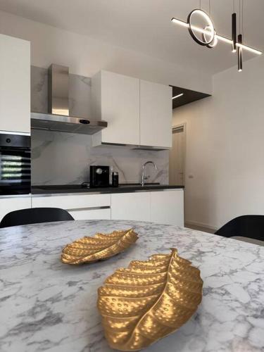 a kitchen with a marble table with two gold shoes on it at Appartamento Dolce Vita - Parking & Self Check-in in Como