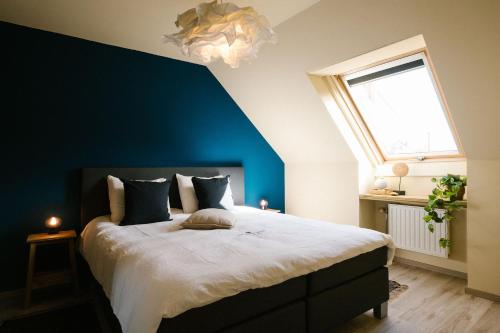 ein Schlafzimmer mit einem großen Bett mit blauer Wand in der Unterkunft Hoeve de Reetjens - La Gouvernante in Bilzen