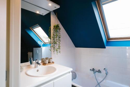 baño con lavabo y techo azul en Hoeve de Reetjens - La Gouvernante en Bilzen