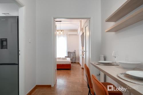 a kitchen with a counter and a room with a bed at Herod Apartment by LobbySquare in Athens