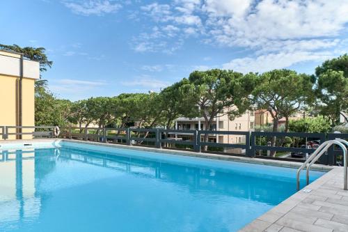 een groot zwembad met bomen op de achtergrond bij Lydie apt. exclusive holigarda in Desenzano del Garda