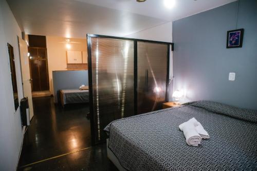 メンドーサにあるApart Hotel Andinoのベッドルーム1室(ベッド1台、シャワー、タオル付)