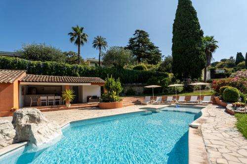 - une piscine dans une cour avec des chaises et des parasols dans l'établissement Dream Villa 300m2 & stunning 4000m2 private garden, à Cannes