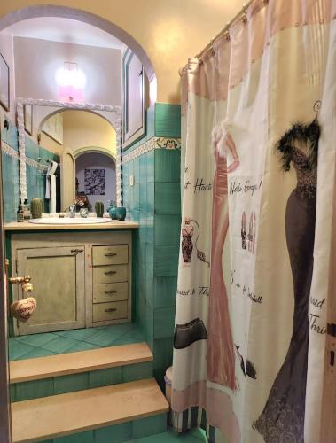 a bathroom with a shower curtain with a picture of a woman at YourHome - La Dimora Di Nonna Angela in Positano