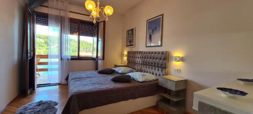 1 dormitorio con cama y ventana grande en Apartment Next to the sea, en Jelsa