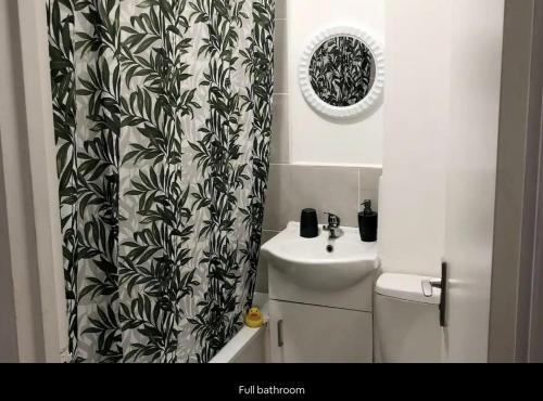 a bathroom with a sink and a shower curtain at Lovely Flat in Central London in London